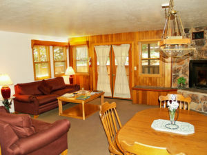 Photo of living room with double doors, fireplace, table, coffee table and 2 red sofas